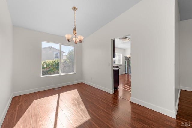 unfurnished dining area with a notable chandelier, a healthy amount of sunlight, and dark wood-type flooring