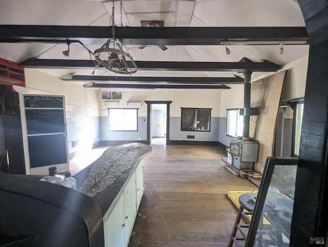 kitchen featuring dark wood-type flooring, vaulted ceiling with beams, and a healthy amount of sunlight