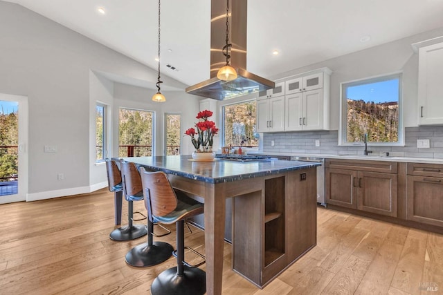 kitchen with white cabinetry, a kitchen island, a sink, and island range hood