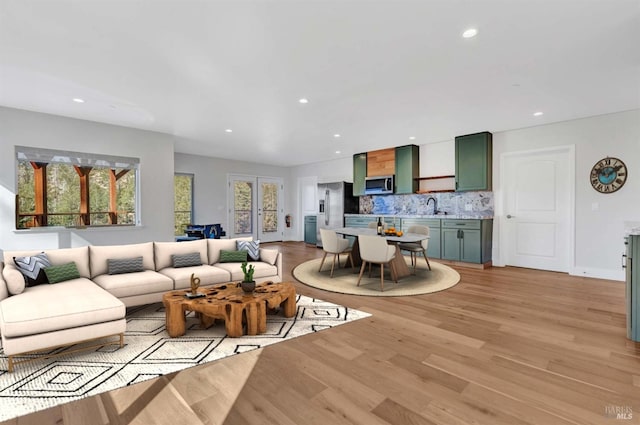 living room with baseboards, light wood finished floors, and recessed lighting