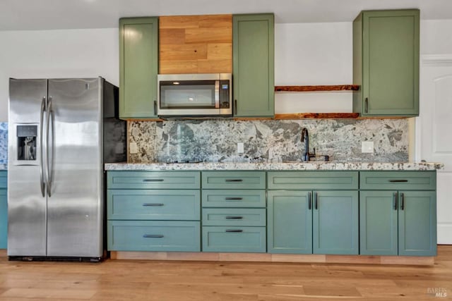 kitchen featuring green cabinets, stainless steel appliances, light wood-type flooring, and open shelves