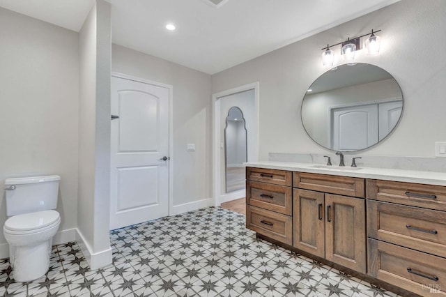 bathroom with vanity, tile patterned floors, toilet, and baseboards