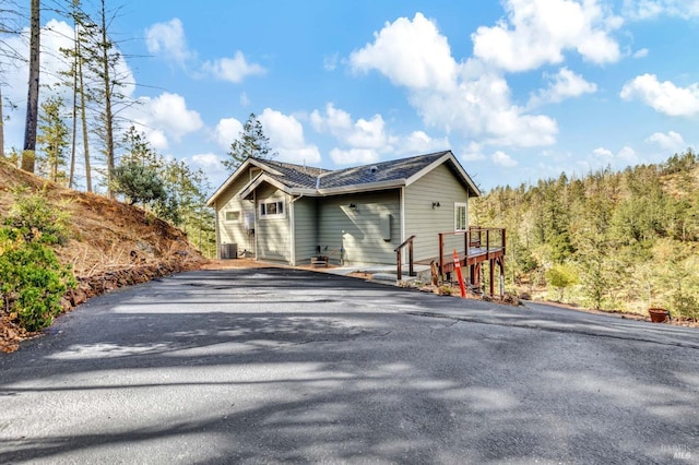 view of property exterior with a deck and central AC