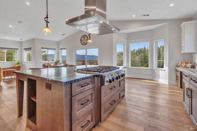 kitchen featuring stainless steel gas cooktop, a kitchen island, white cabinets, brown cabinetry, and island exhaust hood