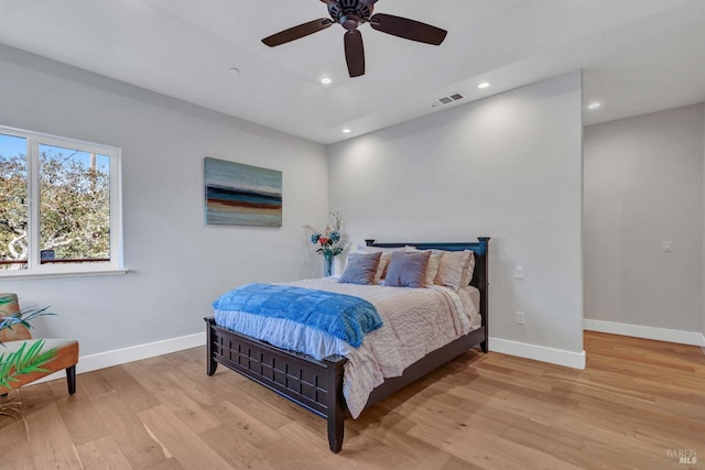 bedroom with a ceiling fan, recessed lighting, light wood-style flooring, and baseboards