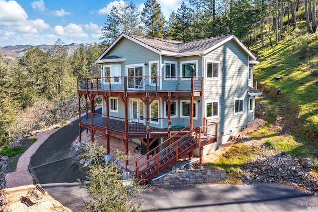 view of front of property with a deck with mountain view and stairs