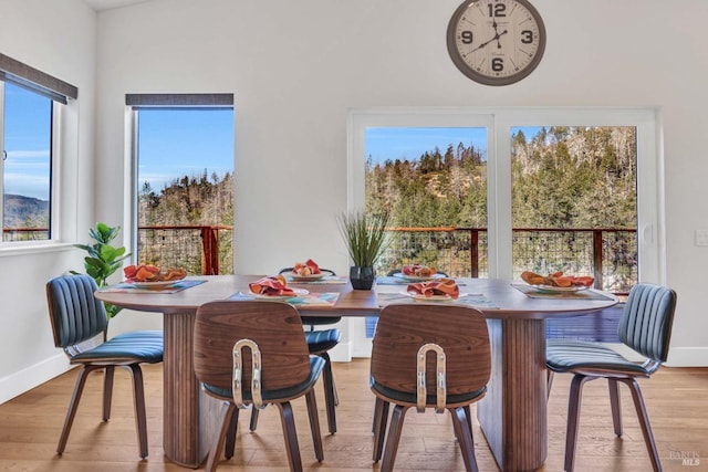 dining area with baseboards and wood finished floors