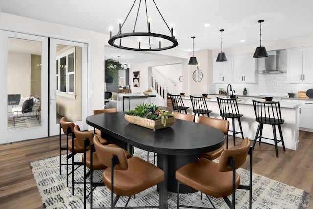 dining area with dark hardwood / wood-style floors, sink, and an inviting chandelier