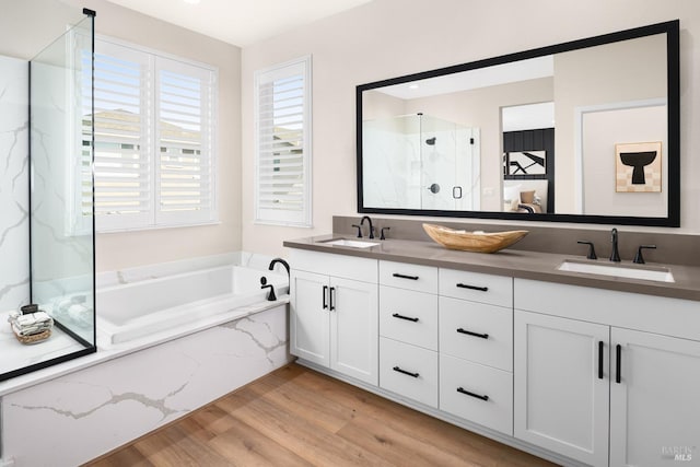 bathroom featuring vanity, hardwood / wood-style flooring, and separate shower and tub