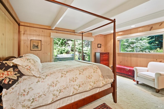 bedroom featuring wooden walls, beamed ceiling, and carpet flooring