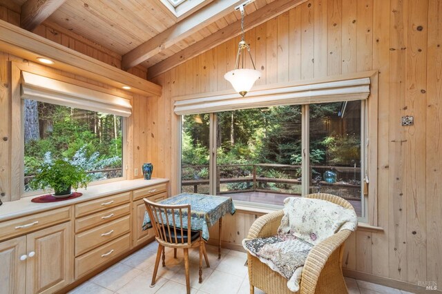 sunroom featuring vaulted ceiling with skylight and wood ceiling