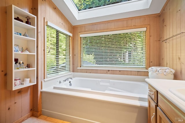 bathroom with a skylight, wooden walls, a bath, and vanity