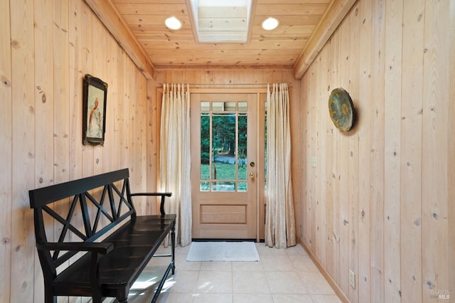 doorway with light tile patterned floors, wood ceiling, and wooden walls