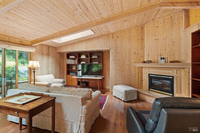 living area with wooden ceiling, wood walls, wood finished floors, lofted ceiling with skylight, and a glass covered fireplace