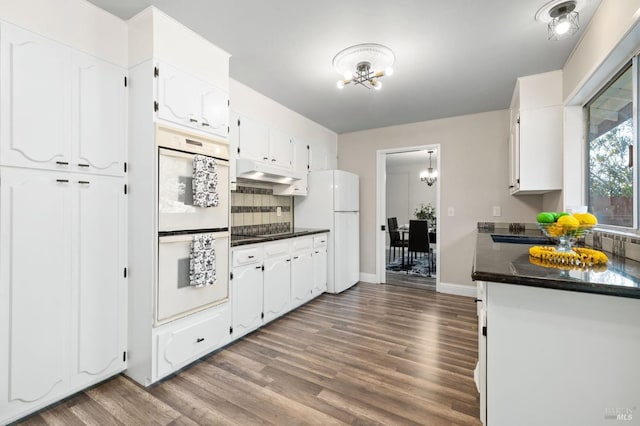 kitchen featuring white cabinets, dark hardwood / wood-style flooring, white appliances, and backsplash