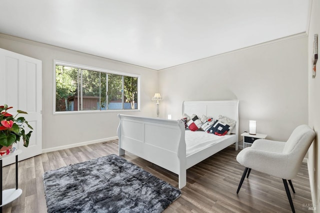 bedroom with hardwood / wood-style floors and crown molding