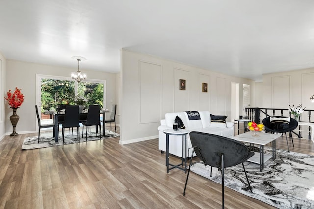 living room with hardwood / wood-style floors and a notable chandelier