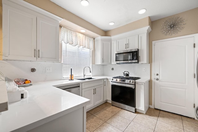 kitchen featuring light tile patterned floors, stainless steel appliances, white cabinetry, and sink