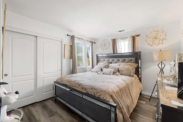 bedroom with dark hardwood / wood-style floors and a closet