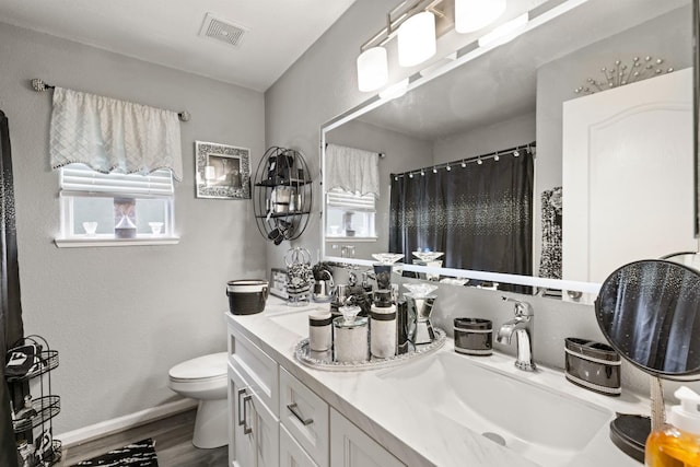 bathroom featuring curtained shower, hardwood / wood-style floors, vanity, and toilet