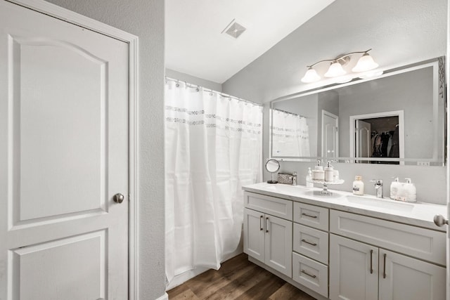 bathroom with hardwood / wood-style floors, vanity, and walk in shower