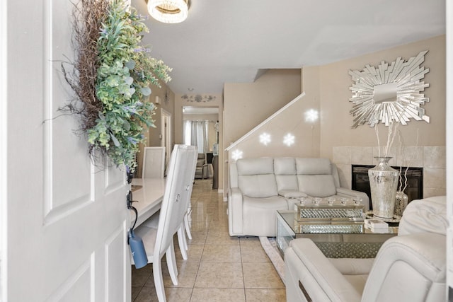 tiled living room featuring a notable chandelier and a tiled fireplace