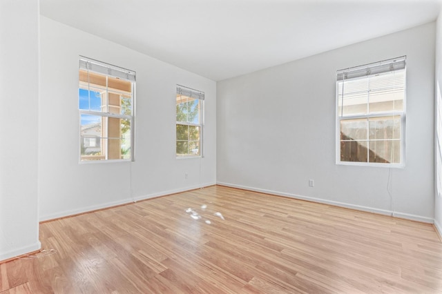 spare room with light hardwood / wood-style flooring and a wealth of natural light