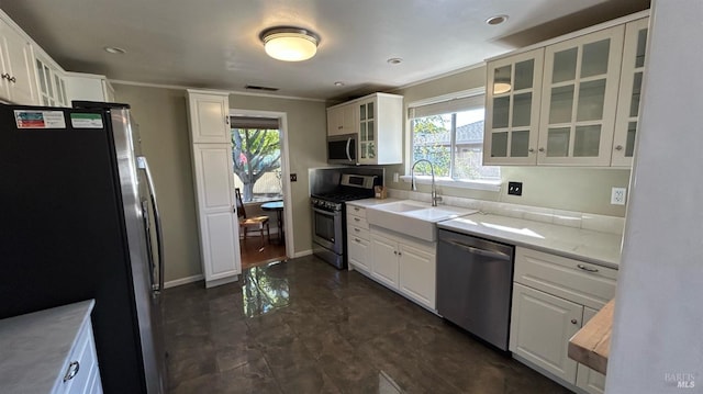 kitchen featuring white cabinets, stainless steel appliances, sink, and light stone countertops