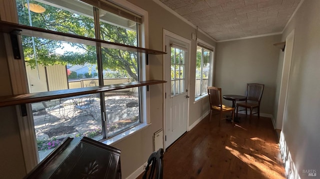 doorway with dark wood-type flooring, a healthy amount of sunlight, and crown molding