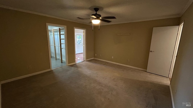 carpeted spare room with ornamental molding and ceiling fan