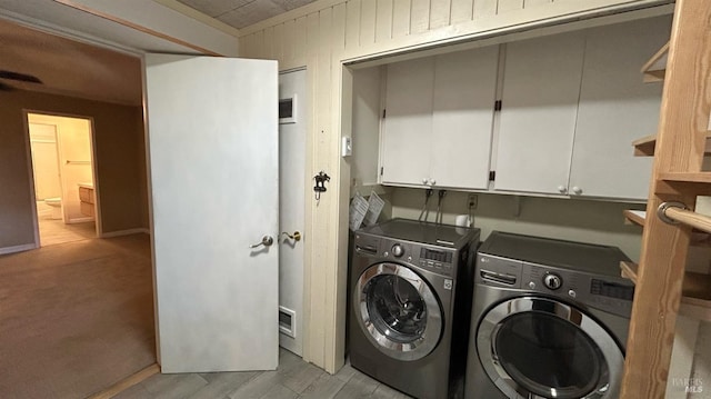 laundry area with cabinets, separate washer and dryer, and light wood-type flooring