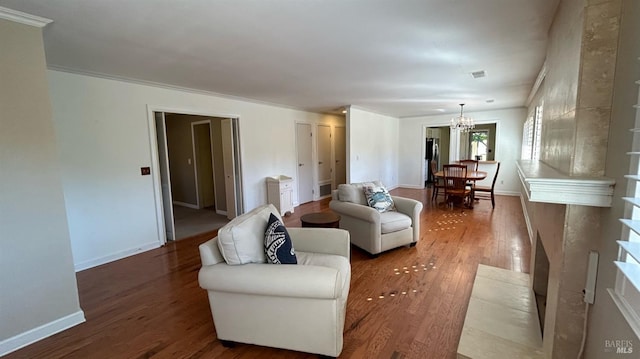 living room with an inviting chandelier, hardwood / wood-style flooring, and ornamental molding