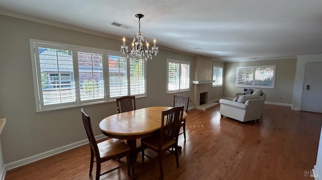 dining space with dark hardwood / wood-style flooring, an inviting chandelier, and ornamental molding