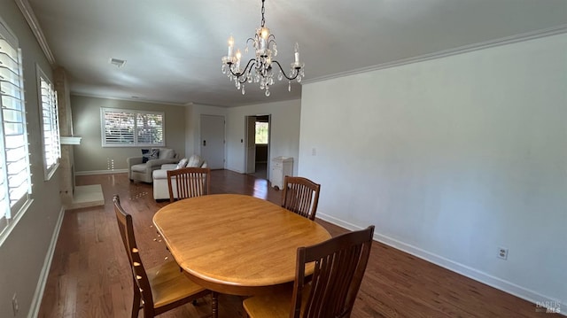 dining room featuring dark wood-type flooring, a chandelier, and ornamental molding