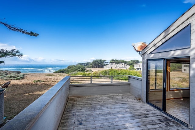 exterior space with a balcony, a water view, and a beach view