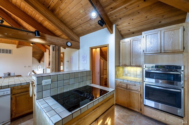 kitchen featuring tile countertops, light hardwood / wood-style flooring, wooden ceiling, and black stovetop