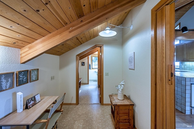 kitchen featuring tile countertops, lofted ceiling with beams, appliances with stainless steel finishes, tasteful backsplash, and light tile patterned flooring