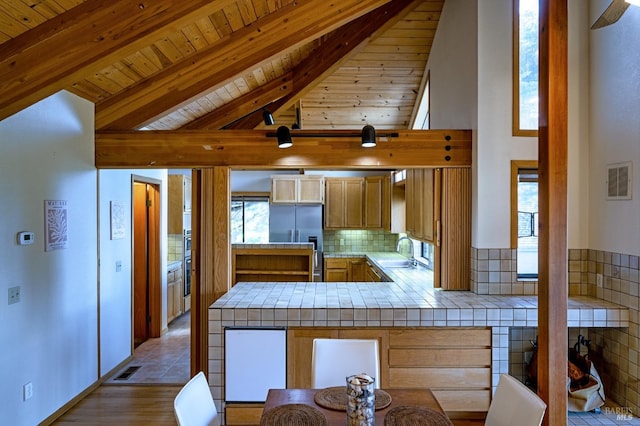 corridor with beamed ceiling, high vaulted ceiling, light hardwood / wood-style flooring, and wooden ceiling