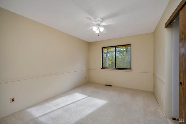 unfurnished room with ceiling fan and light colored carpet