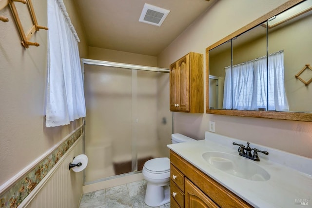 bathroom with toilet, vanity, and an enclosed shower