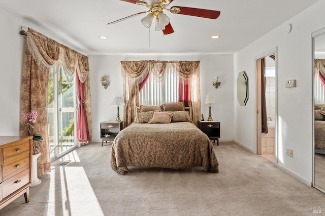 carpeted bedroom with ensuite bathroom, access to outside, multiple windows, and ceiling fan