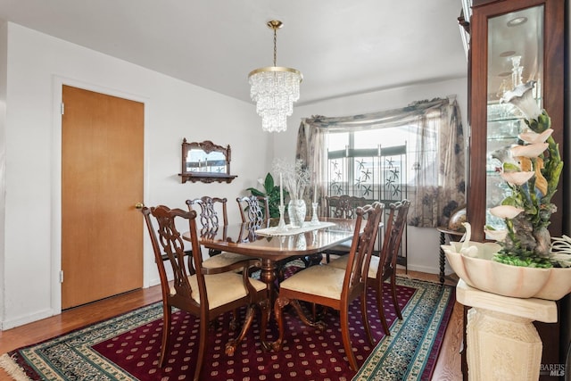 dining space featuring wood-type flooring and a chandelier