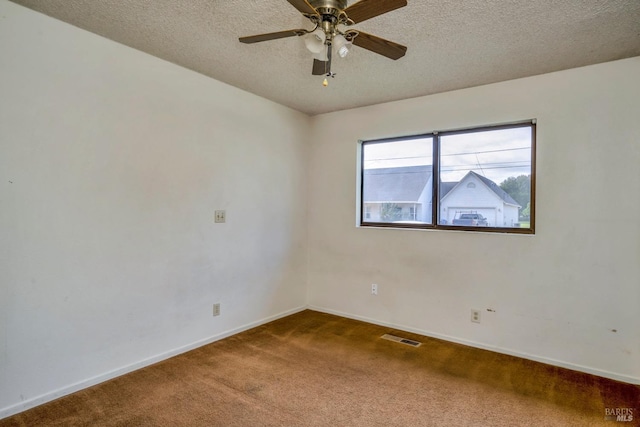 carpeted spare room featuring ceiling fan and a textured ceiling