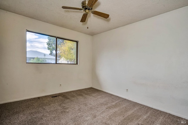 carpeted spare room featuring ceiling fan and a textured ceiling