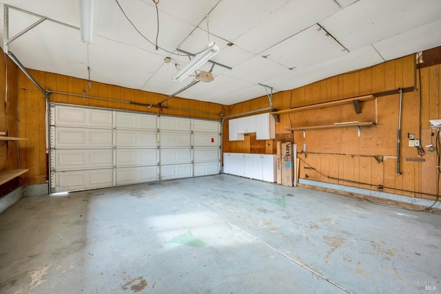 garage with a garage door opener and wood walls