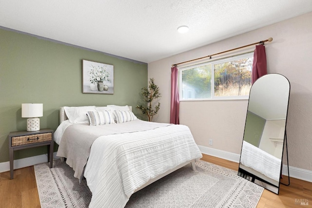 bedroom featuring baseboards and wood finished floors