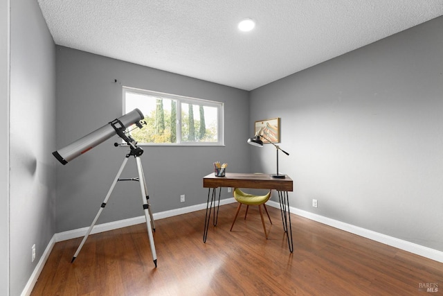 office space featuring a textured ceiling, wood finished floors, and baseboards