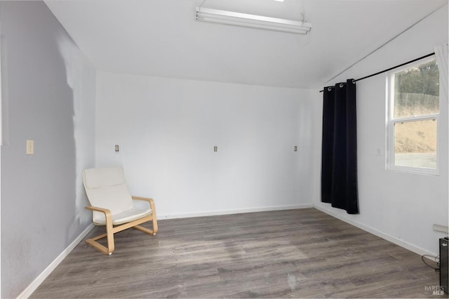 unfurnished room featuring wood-type flooring and vaulted ceiling