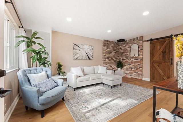 living area featuring light wood-type flooring, recessed lighting, baseboards, and a barn door