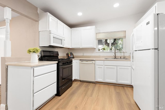 kitchen featuring light wood-type flooring, white appliances, light countertops, white cabinets, and a sink